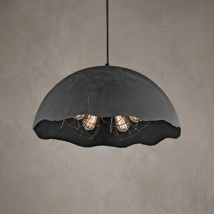 Kichler Fracture zinc pendant light with a textured dome shade and five wire-caged bulbs against a neutral wall.