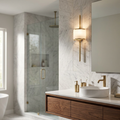 Sleek natural brass wall light with a white cylindrical shade mounted on a marble wall in a modern bathroom.