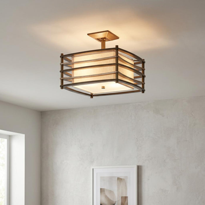 Bronze semi-flush ceiling light with a slatted metal cage and linen shade, illuminated in a modern interior.