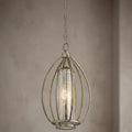 Kichler Rosalie one-light gold pendant with an oval cage and mercury glass shade against a neutral wall.