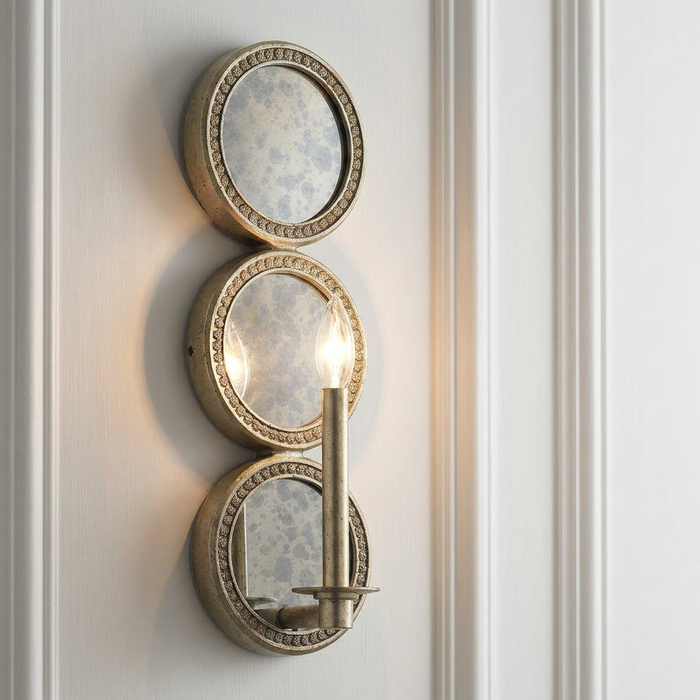 Kichler Rosalie gold wall sconce featuring three stacked antiqued mirror panels mounted on a white wall.