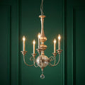 Five-light gold chandelier with a crackled glass orb and crystal drop, set against a dark green paneled wall.