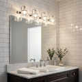Kichler Talland four-light chrome wall fixture with seeded glass shades mounted above a bathroom vanity mirror.