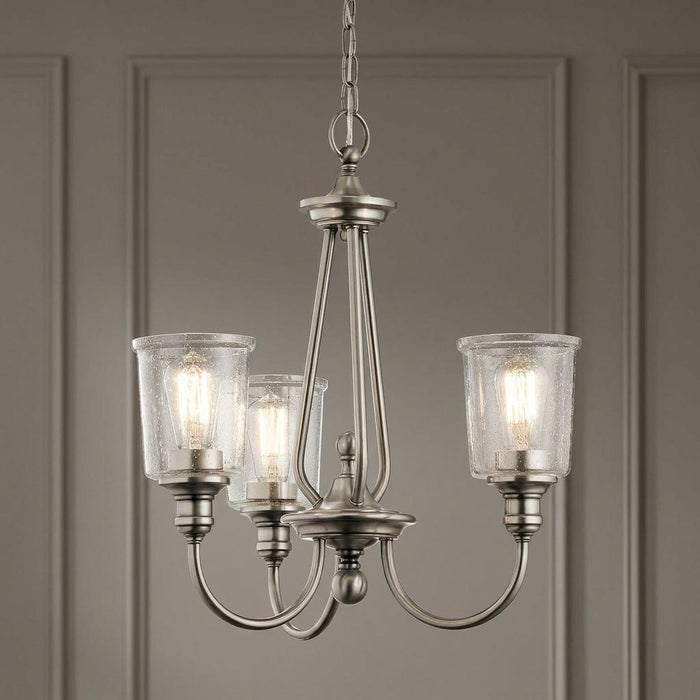 Kichler Waverly 3-light chandelier in classic pewter with seeded glass shades and lit filament bulbs.