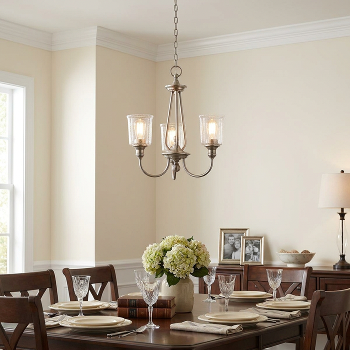 Kichler Waverly 3-light classic pewter chandelier with seeded glass shades hanging over a set dining table.