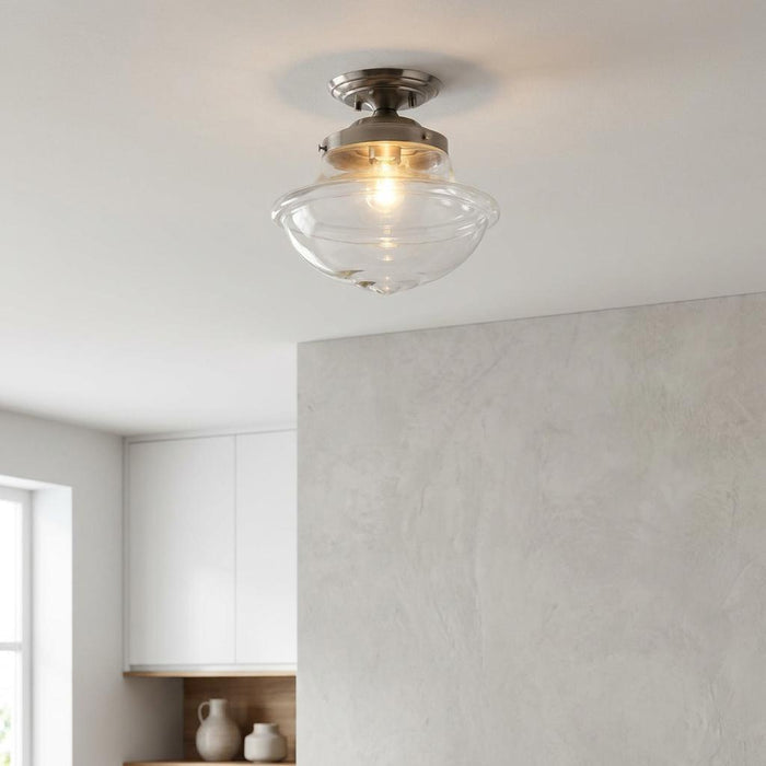 Lars clear glass flush ceiling light with antique chrome fixture glowing against a white ceiling.