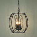Four-light silver brushed black pendant with a geometric orb-shaped wire cage against a sage green wall.