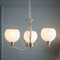 Luanda 3-light antique chrome chandelier featuring curved arms and frosted white glass globes.