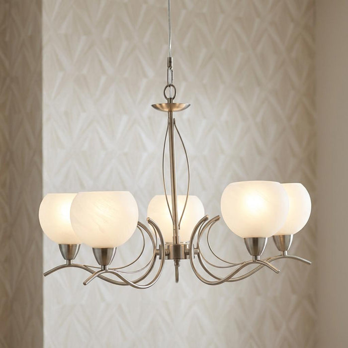 Luanda 5 light antique chrome chandelier with frosted glass shades against a neutral patterned wall.