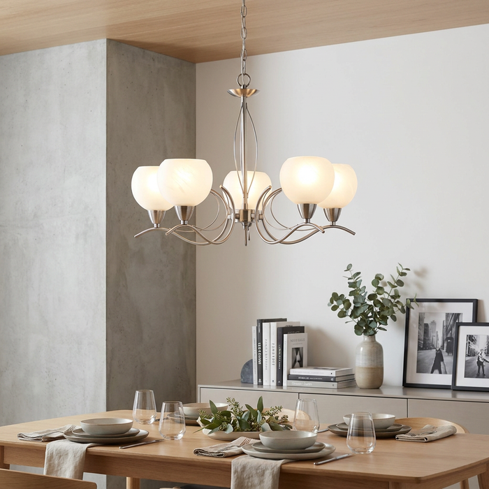 Luanda 5-light antique chrome chandelier with opal glass globes hanging above a set dining table.