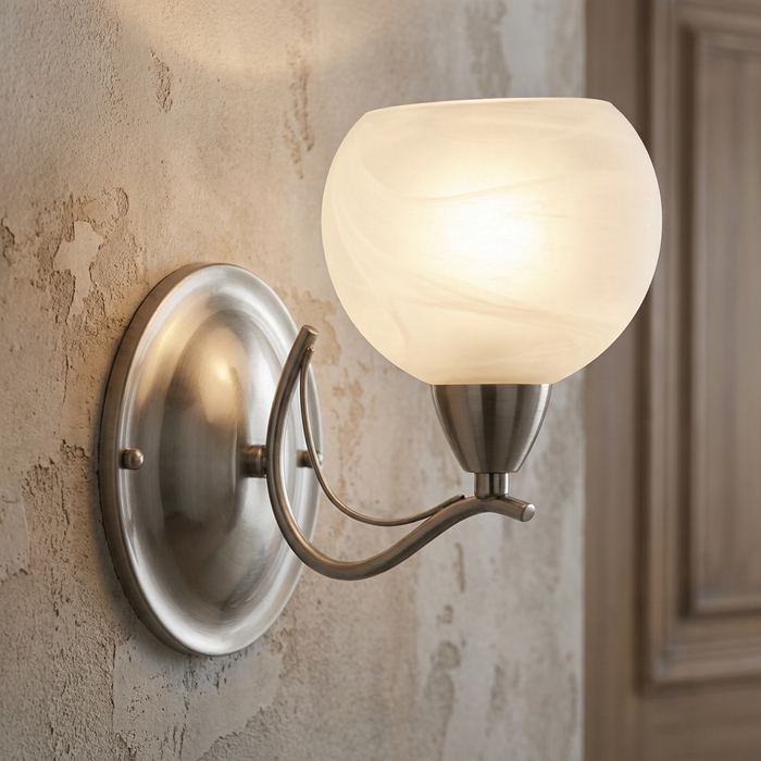 Luanda antique chrome wall light with a glowing marbled glass shade mounted on a rustic textured wall.