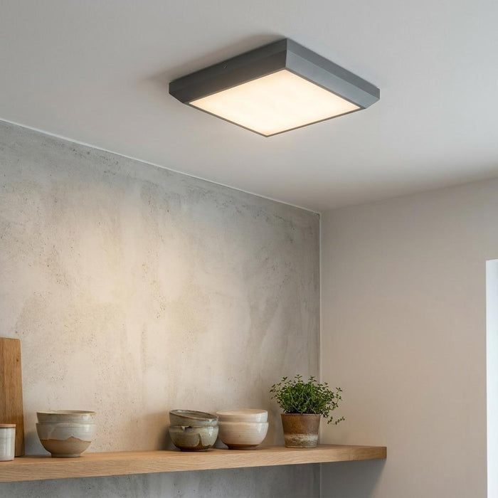 Square grey Lutec Helena LED ceiling light illuminates a modern interior with wooden shelves and a concrete wall.