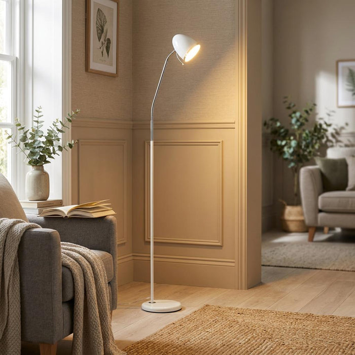 White floor lamp with an adjustable chrome neck casting a warm glow in a cozy, neutral living room.