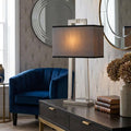 Magro polished nickel table lamp with a grey rectangular shade on a dark wooden console table.