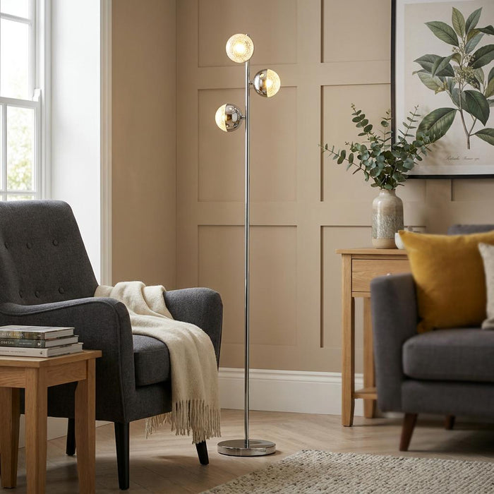 Marbles Modern Chrome Floor Lamp with three glowing spherical shades in a contemporary living room.