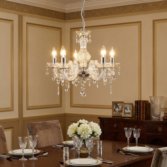 Elegant 5-light clear acrylic chandelier with crystal droplets hanging over a formally set dining table.
