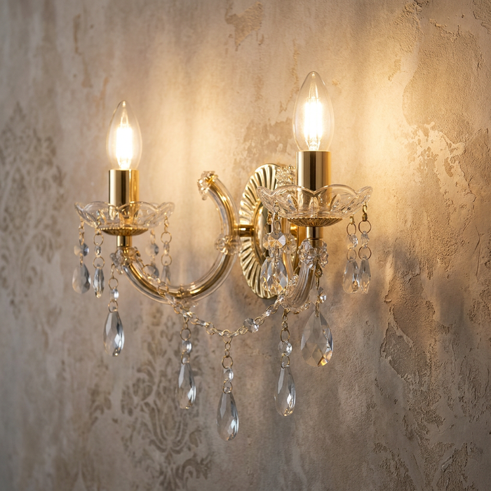 Marie Therese two-light brass and crystal glass wall light with hanging droplets on a textured wall.