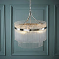 Marietta 3-light nickel and glass rod ceiling pendant with tiered glass rods against a blue paneled wall.