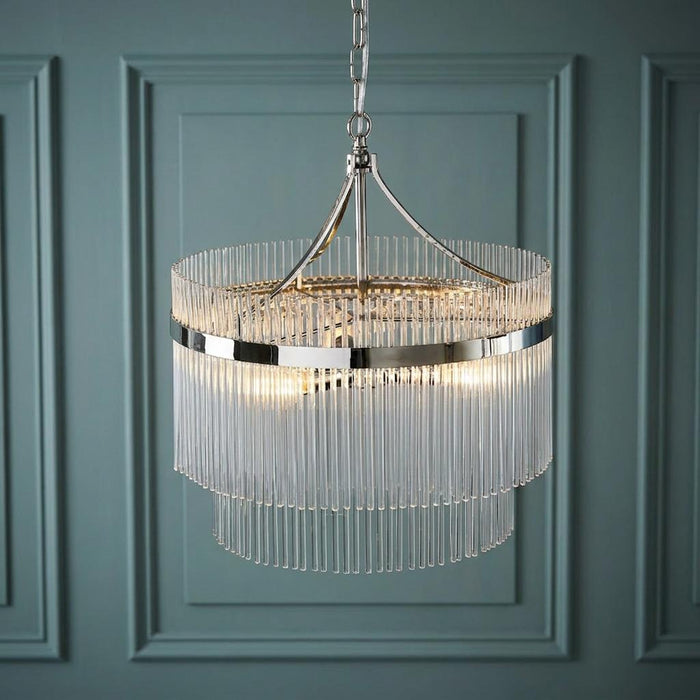 Marietta 3-light nickel and glass rod ceiling pendant with tiered glass rods against a blue paneled wall.