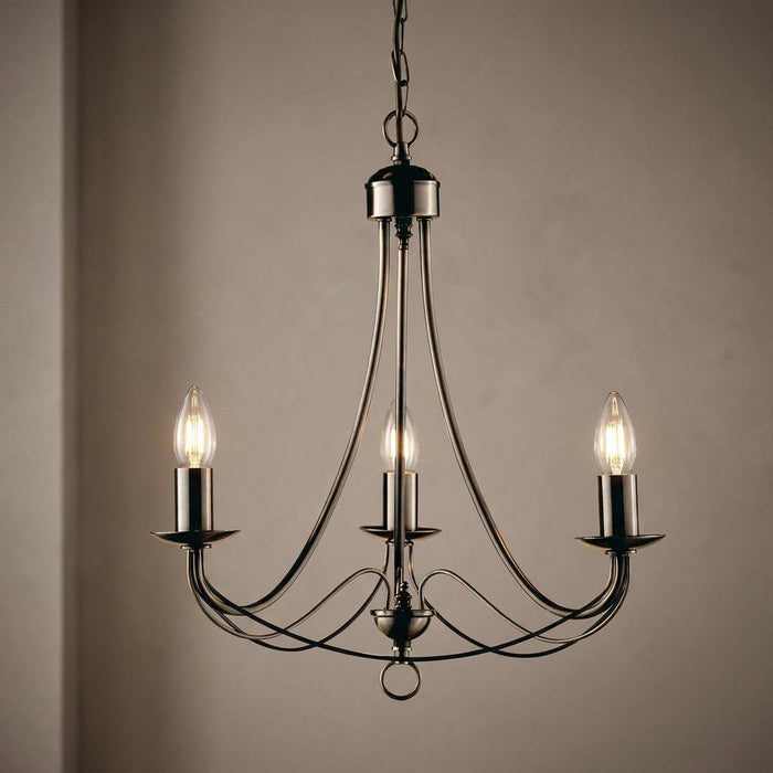 Elegant 3-light antique brass chandelier with curved arms and exposed candle-style bulbs against a neutral wall.