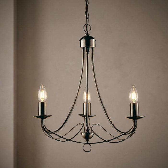 Antique brass ceiling pendant with three candle-style lights and elegant curved arms.