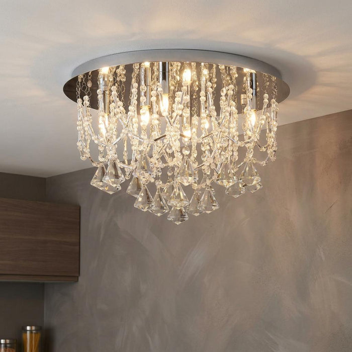Elegant chrome flush ceiling light with cascading crystal beads and pyramid drops illuminating a room.