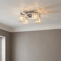Mizar chrome flush ceiling light featuring four crystal cube shades casting a warm glow on a white ceiling.