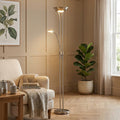 Satin silver mother and child LED floor lamp lighting a living room with a beige armchair and indoor plant.
