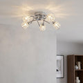 Naira 5-light chrome flush ceiling fixture with illuminated crystal shades in a modern interior setting.