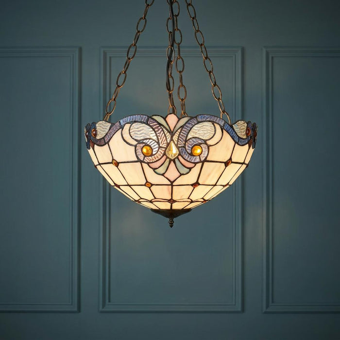Newcastle Inverted Tiffany Ceiling Light with a decorative stained glass shade hanging against a blue paneled wall.
