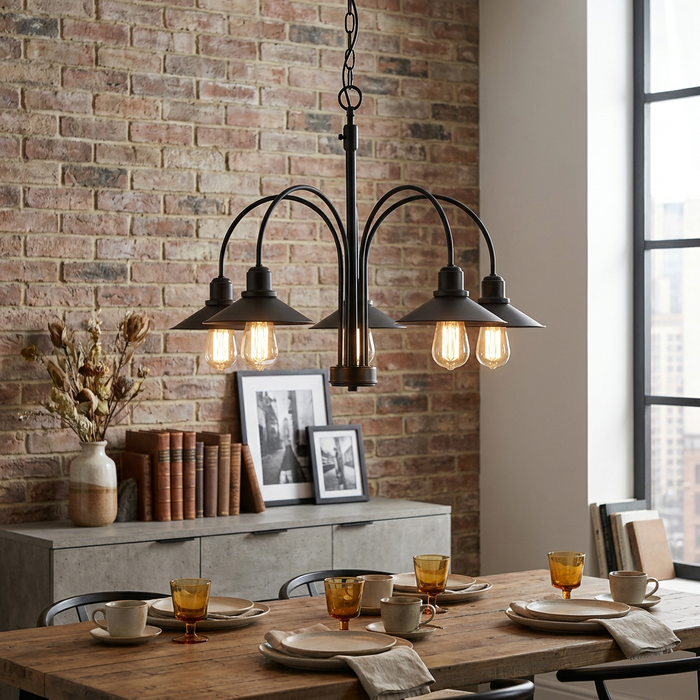 Five-light black metal chandelier with arched arms and filament bulbs hanging over a wooden dining table.