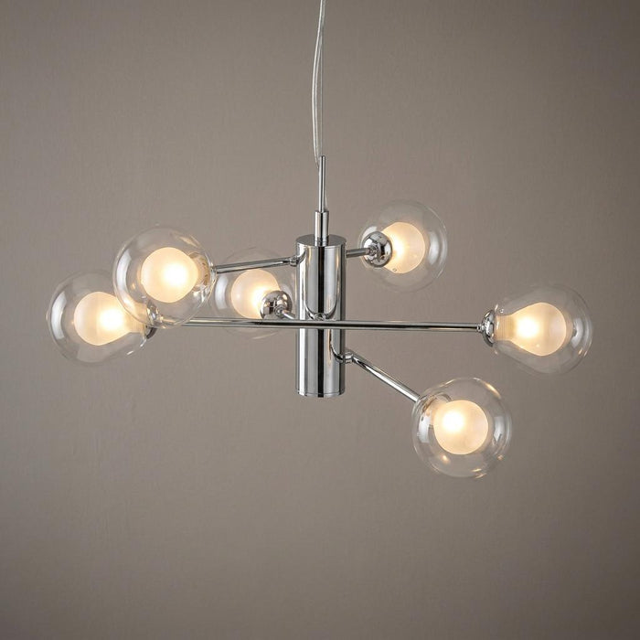 Oaks Harren 6 light chrome ceiling pendant with clear glass globe shades and warm glowing bulbs.