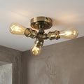 Industrial 3-light antique brass flush ceiling fixture with exposed filament bulbs.