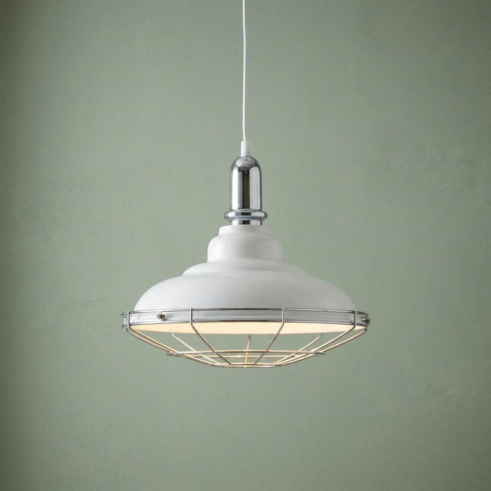 White domed ceiling pendant with chrome wire cage and hardware against a pale green wall.