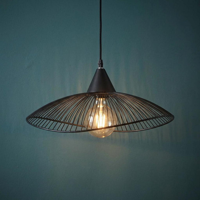 Black wireframe pendant light with a glowing filament bulb against a dark teal wall.