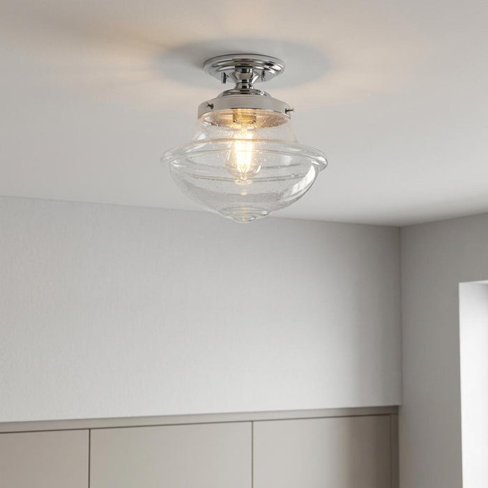 Oaks Lighting Lars flush ceiling light with a clear seeded glass shade and chrome fitting, illuminated.