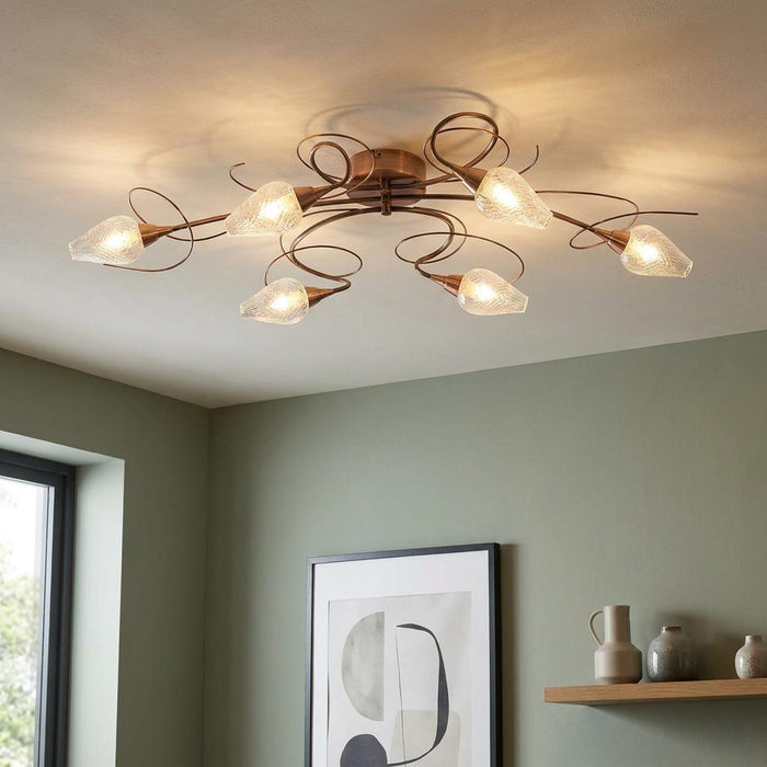 Lugh 6-arm copper semi-flush ceiling light with swirling arms and ribbed glass shades in a modern green room.
