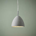 Grey concrete dome pendant light with chrome accents hanging against a sage green wall.