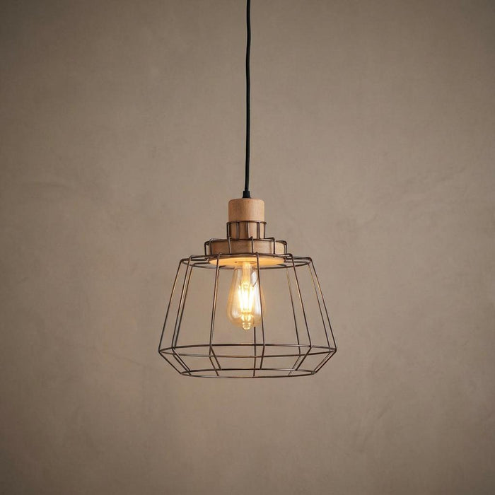 Copper wire frame and wood ceiling pendant light with a glowing bulb against a neutral background.