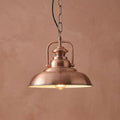 Industrial copper pendant light with a domed shade hanging against a textured terracotta-colored wall.