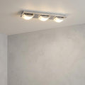 Modern three-light chrome LED ceiling fixture with curved frosted glass shades on a light gray ceiling.