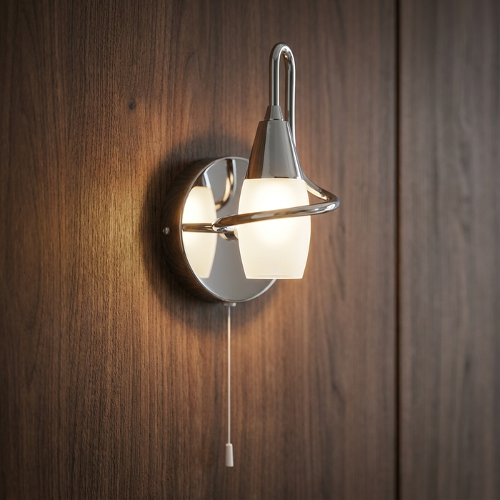 Chrome wall light with a frosted glass shade and pull cord, glowing on a dark wood panel.