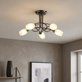 Modern 5-light semi-flush ceiling fixture in mirror black with oval frosted glass shades in a contemporary room.