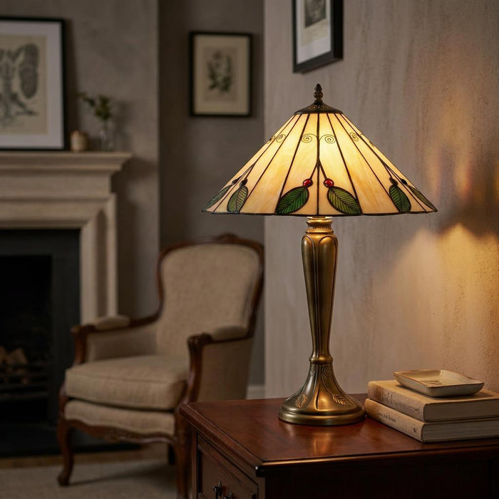 Tiffany table lamp with leaf patterned shade and brass base on a wooden side table in a warm living room.