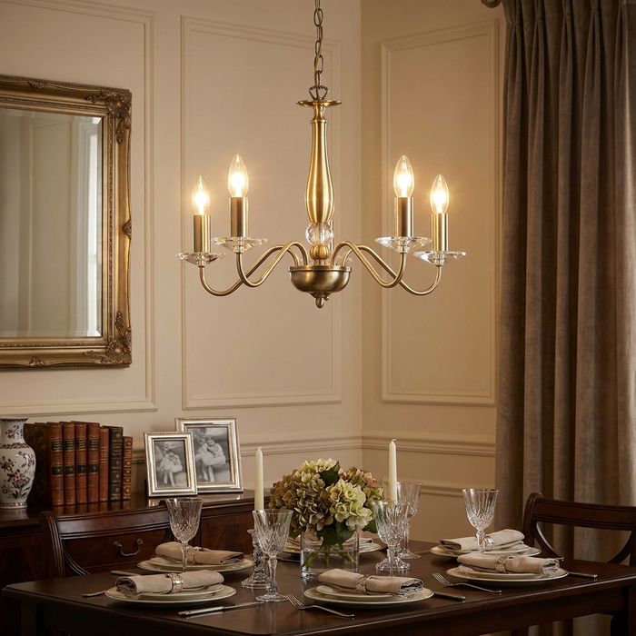Oaks Vesta 5-light antique brass chandelier illuminating a formally set dining table in a classic interior.