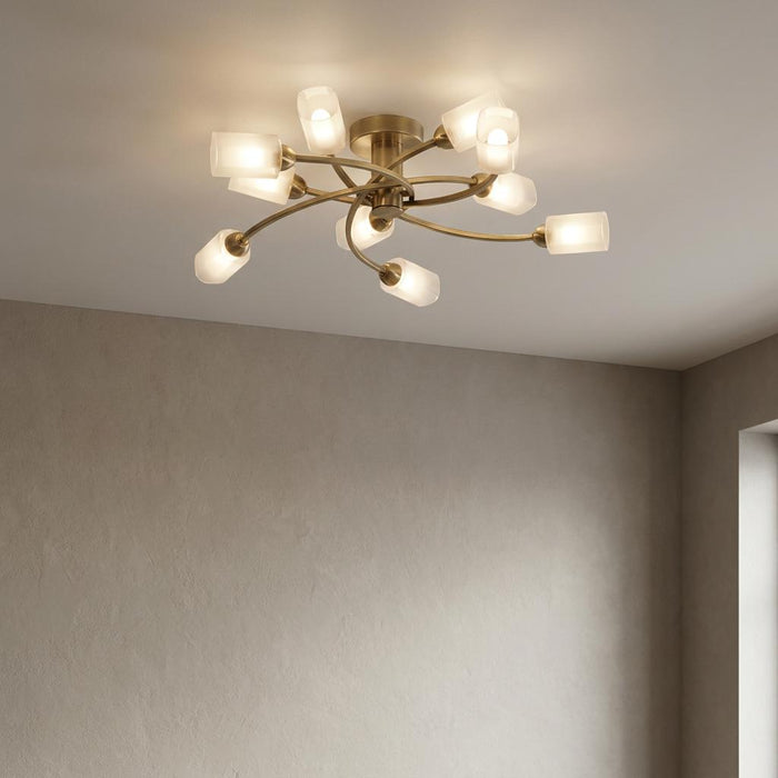 Ofira 10-light antique brass flush ceiling light with curved arms and glowing opal glass shades.
