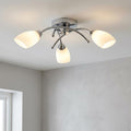 Modern three-light chrome flush ceiling light with illuminated opal glass shades against a white ceiling.