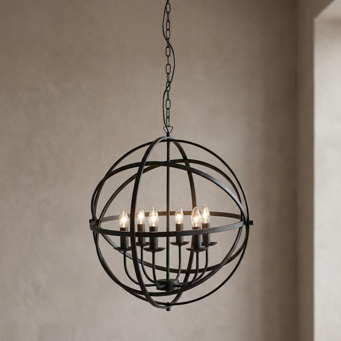 Black spherical cage pendant light with six candle-style bulbs hanging from a chain against a neutral wall.