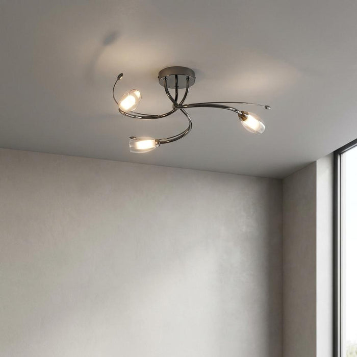 Pandora 3 light mirror black flush ceiling light with curved arms and glass shades illuminated in a minimalist room.