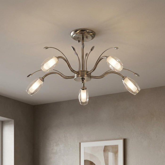 Antique chrome semi-flush ceiling light with five curved arms and clear glass shades mounted on a light gray ceiling.